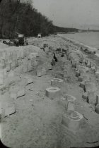Parts of long concrete pier on the beach